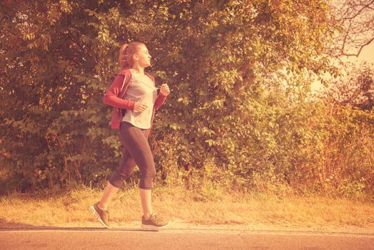 woman jogging along a country road photo