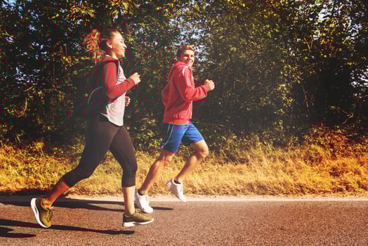 young couple jogging along a country road photo