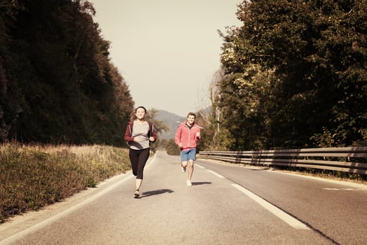 young couple jogging along a country road photo
