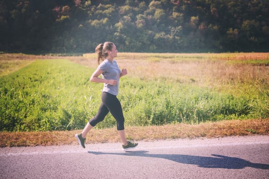 woman jogging along a country road photo