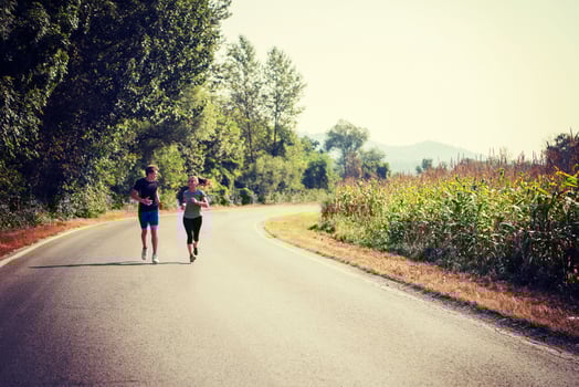 young couple jogging along a country road photo