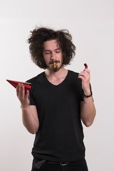 Portrait of a man in party hat blowing in whistle photo