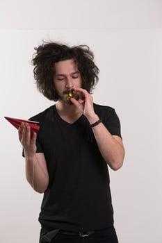 Portrait of a man in party hat blowing in whistle photo