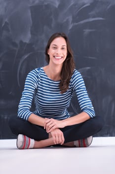 woman sitting in front of chalk drawing board photo