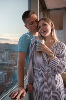 young couple enjoying evening coffee by the window photo