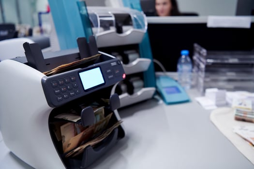 banknotes in front of electronic money counting machine photo