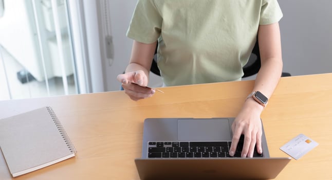 Online shopping. Young woman holding credit card and using laptop at home. African american girl working on computer at cafe. Business, e-commerce, internet banking, finance, freelance concept photo