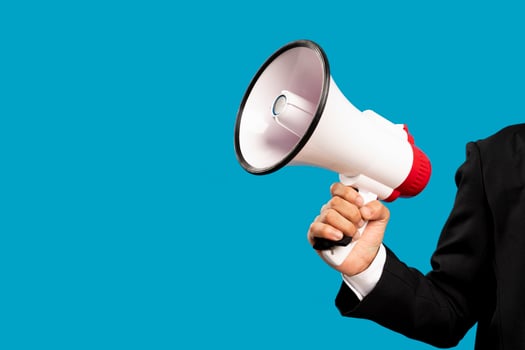 Announcement concept. Hand holds megaphone. Isolated on blue background. photo