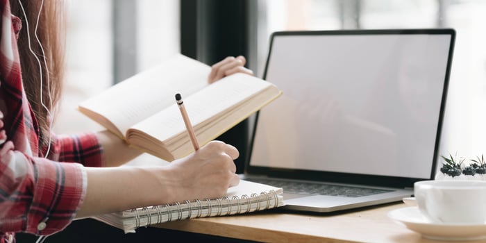 Cropped image Young female freelancer blogger influencer writing notes on her diary photo