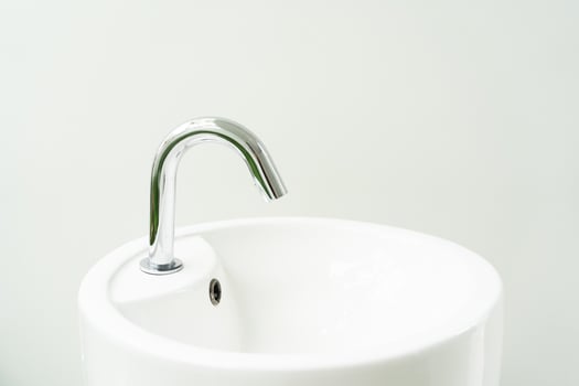 Hygienic wash basin with chrome faucet on bathroom window background. White hand washing sink photo