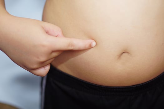 Fat boy, put the index finger on the belly himself. Health, treatment and exercise concept. photo