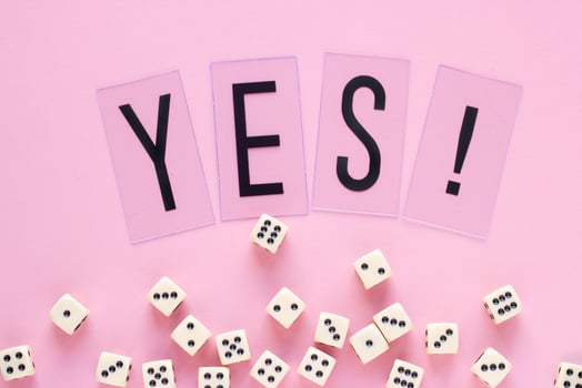 Gaming dice with word YES on pink background. Concept for games, game board, presentation, banners or web. Top view. Close-up photo