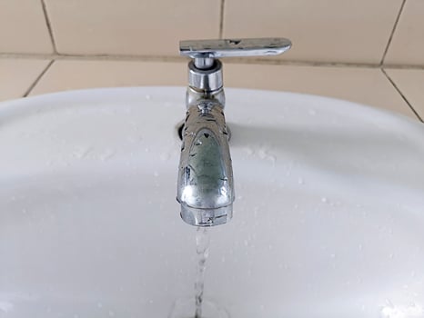 Open faucet in bathroom, water is running photo