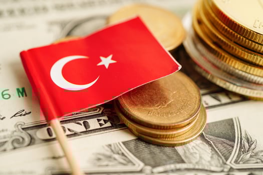 Stack of coins with Turkey flag on USA America dollar banknotes. photo