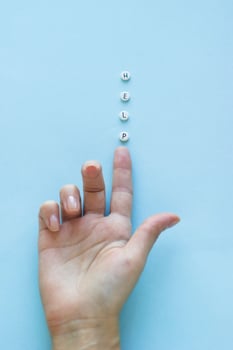 Female hand and tablets with inscription HELP on blue background. Healthcare and medical concept with copy space. Top view. Minimalism photo