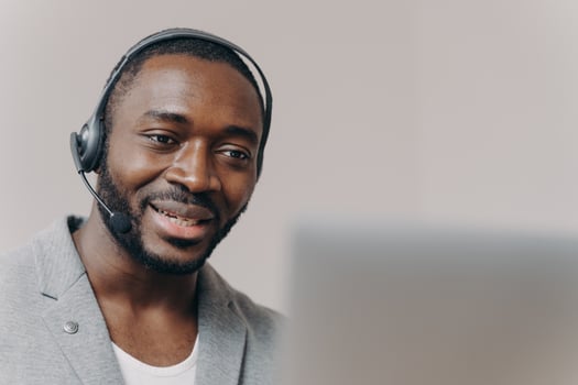 Young pleased african american man callcenter agent talking with client, consulting customer online photo