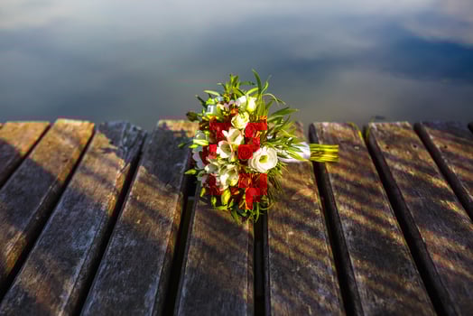 Bouquet of red and white roses flowers on the wooden bridge with evening sun photo