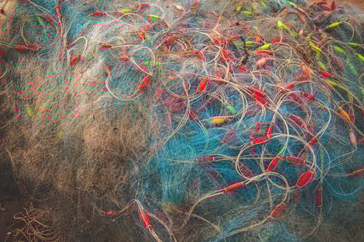 Sea nets - fishing equipment or tackle as texture backdrop with natural sunlight and shadow. Blue textured background of fishing nets close-up, marine design for craft of fishermen. photo