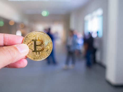 Hand of caucasian young woman holding a bitcoin cryptocurrency coin photo