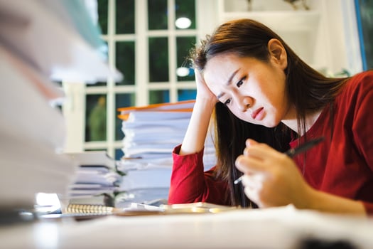 A Stress Woman has a headache during checks reports  during overtime at home photo