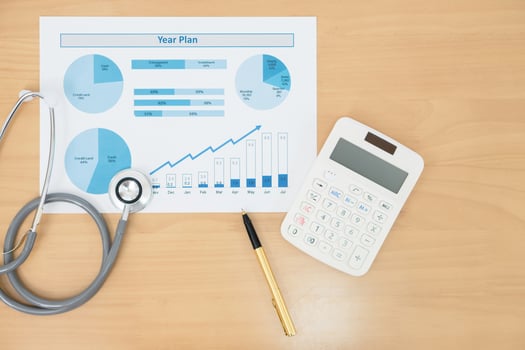 Stethoscope with financial statement, calculator and pen photo