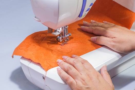 Woman's hands, sewing her patchwork using sewing machine photo