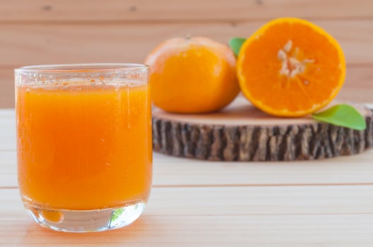 Cold orange juice on wooden table photo