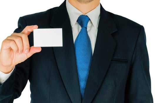 Businessman is holding or showing blank white card isolated over white background. Photo is focused at his hand and included clipping path of white background.