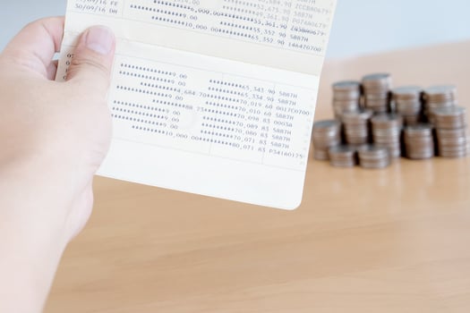 Woman hold passbook on hand, coins background photo