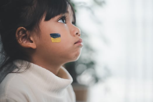 A child with the flag of Ukraine is crying. Sadness longing hope. Children's tears from the war. Evacuation of civilians. Freedom to Ukraine photo