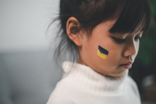 A child with the flag of Ukraine is crying. Sadness longing hope. Children's tears from the war. Evacuation of civilians. Freedom to Ukraine photo