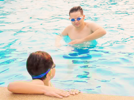 Father teaching his son in a swimming pool photo