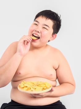Fat boy is happily eating chip photo