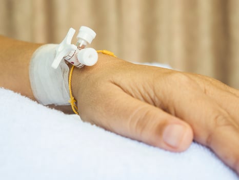 Patient's hand with medicine drip injection, lady on a bed in a hospital photo