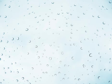 Rain drop stick at glass window over light blue sky background photo