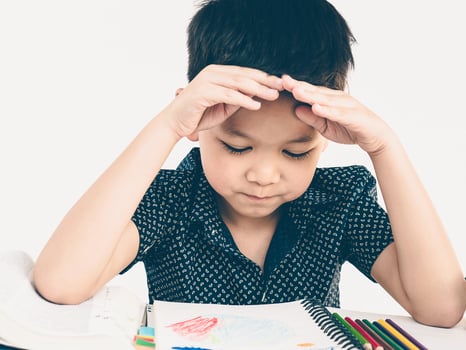 Vintage style photo of a child is thinking and looking at his homework book
