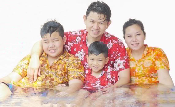 Family of four are playing water during Songkran festival, traditional Thai new year festival photo