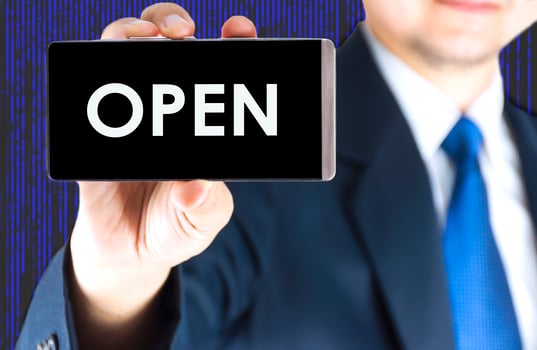 Focused of open word on mobile phone screen in blurred young businessman hand and digital technology background photo