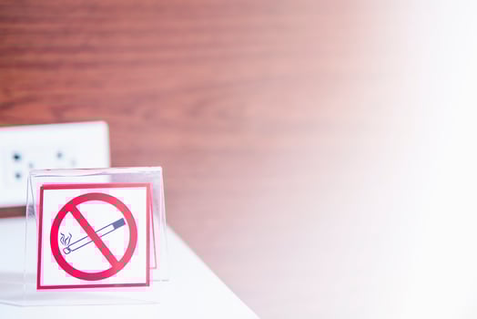 No smoking sign with wooden wall texture background and white light shining from right side photo
