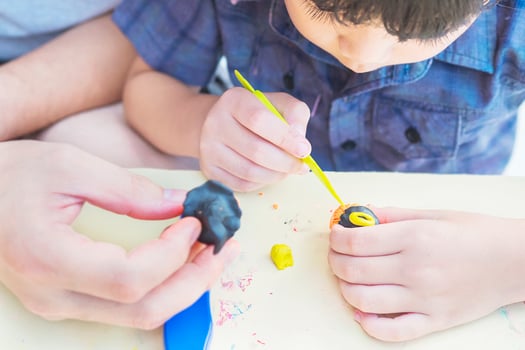 Father is playing Halloween clay with his son over white background.Photo is focus at hand photo
