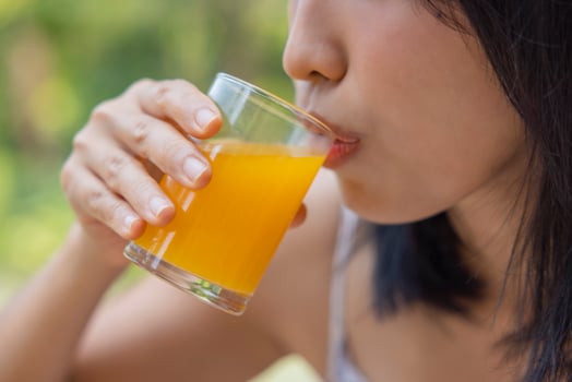 Close up of woman drink orange juice. Girl enjoy fruit juice for lunch, wellbeing diet concept. Concept of health photo
