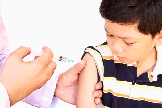Sick Asian boy being treated by male doctor isolated over white background photo