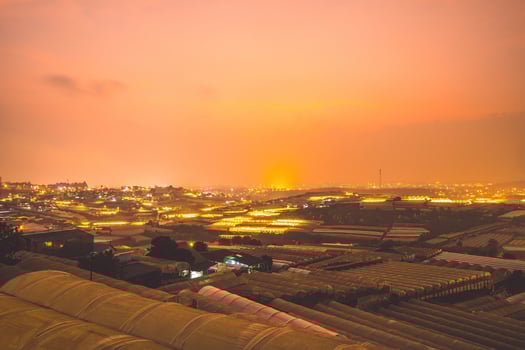Amazing sunset landscape in agricultural greenhouse valley in Da Lat City. The light from the greenhouse to grow flowers in Da Lat. Travel and landscape concept photo