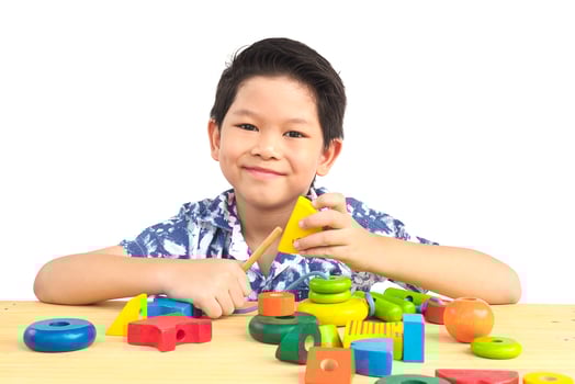 Lovely asian boy is play colorful wood block toy photo