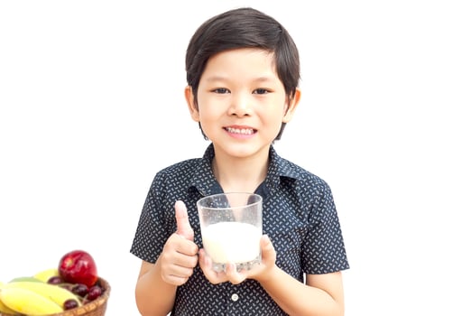 Asian boy is drinking a glass of milk over white background photo