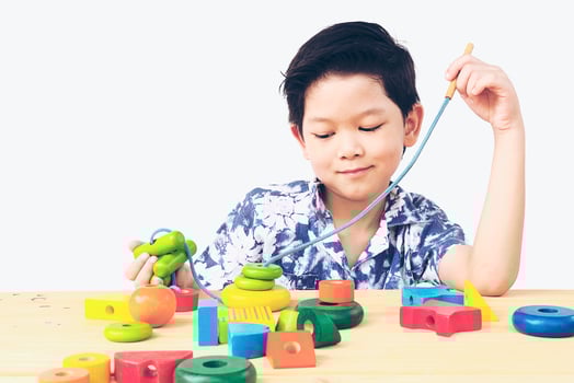 Lovely asian boy is play colorful wood block toy photo