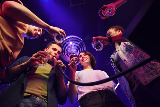Holding glasses in hands. Group of friends having fun in the night club together photo