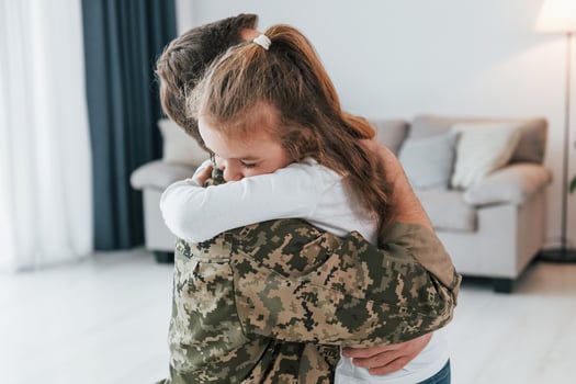 Finally meet each other. Soldier in uniform is at home with his little daughter photo