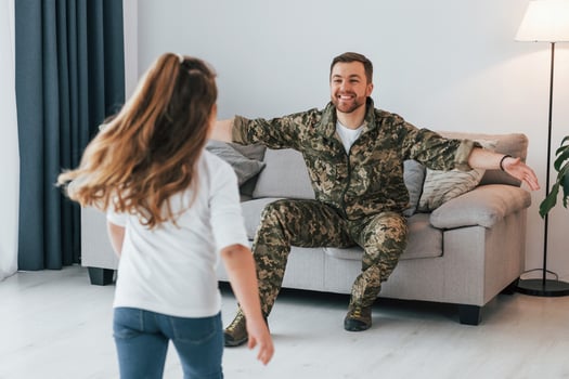 Finally at home. Soldier in uniform is with his little daughter photo