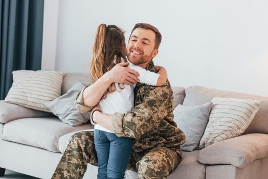 Finally at home. Soldier in uniform is with his little daughter photo